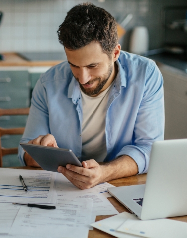 Hombre en una computadora de escritorio usando su tableta