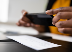 Person taking a picture with a cellphone to a check